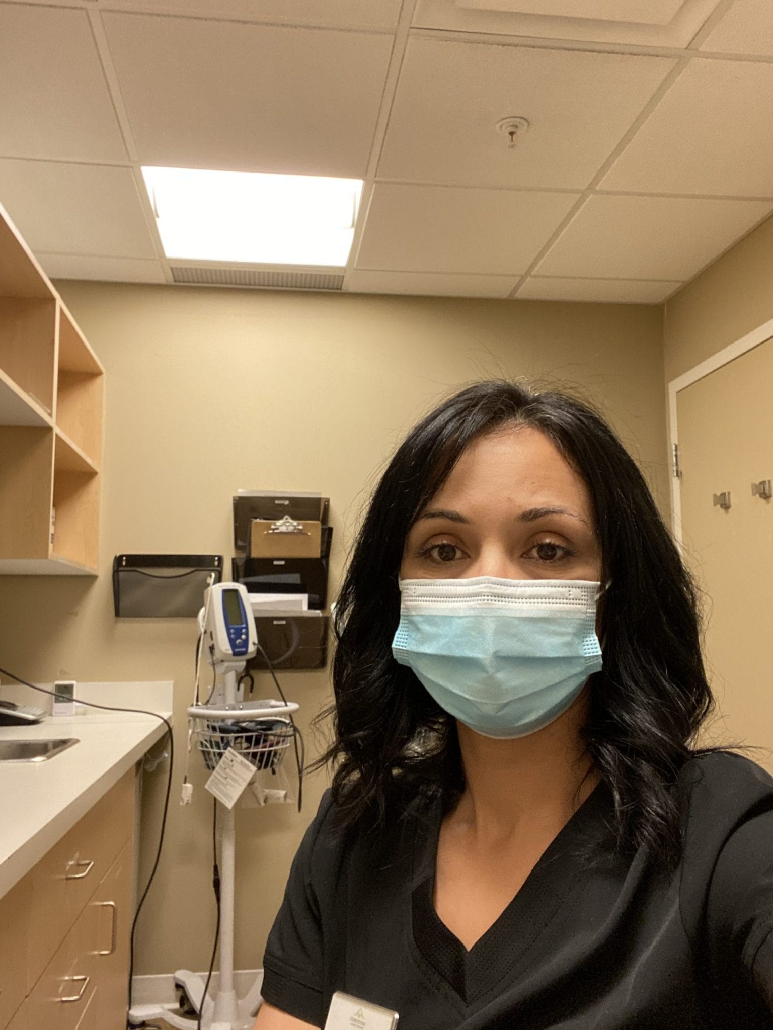 Ashley Schmidt wearing a medical mask, sitting in a medical office.
