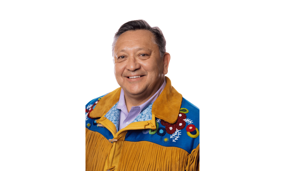 Headshot of a man wearing a beaded leather jacket.
