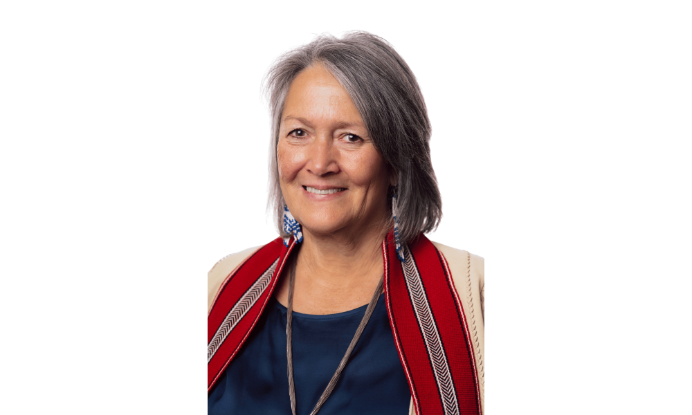 Headshot of a woman wearing a red Metis sash around her shoulders.