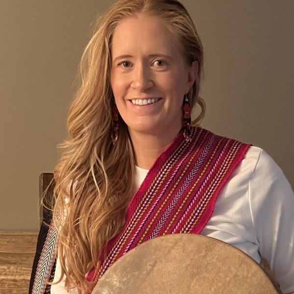 Image of a smiling woman with long hair and a red Metis sash over her shoulder.