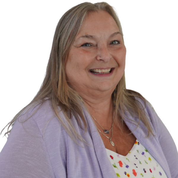 Wendy Schneider is smiling in a purple cardigan and floral shirt against a neutral background.