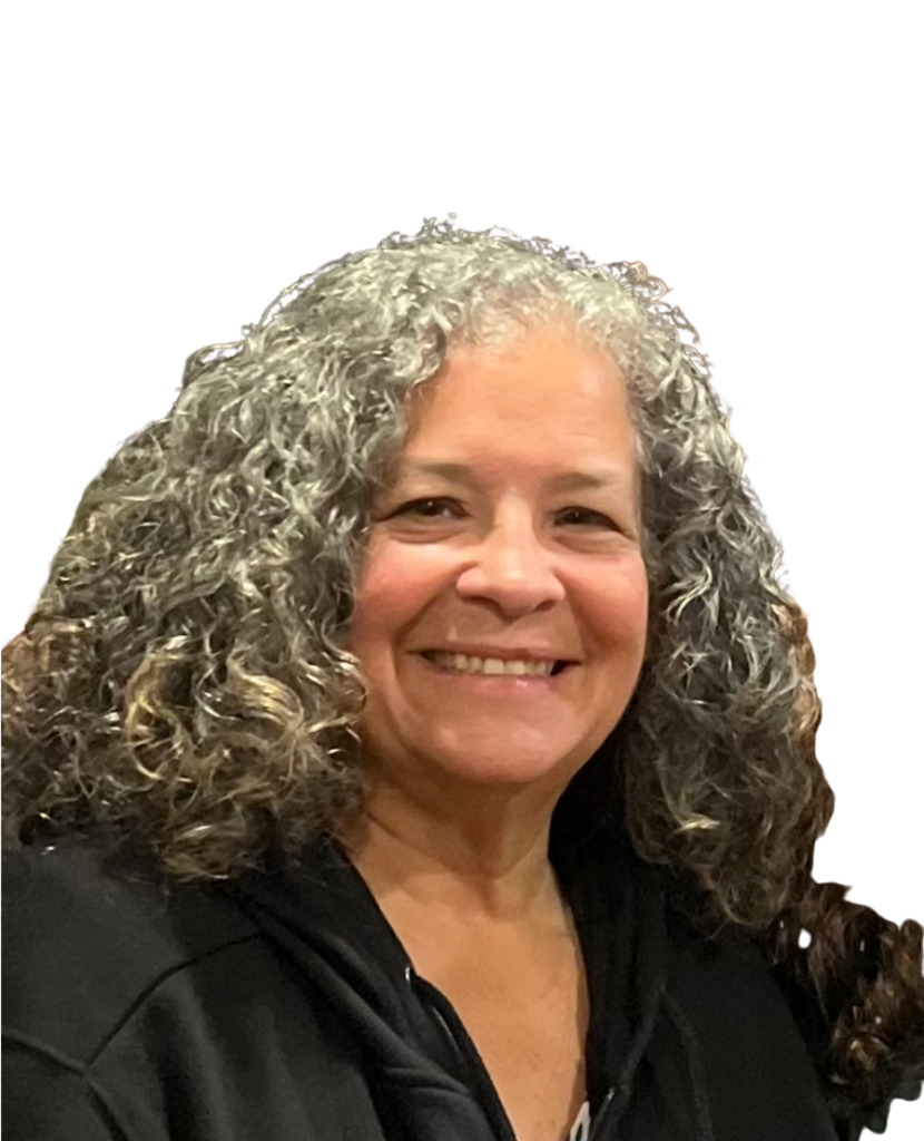 Headshot of a smiling woman with grey curly hair.