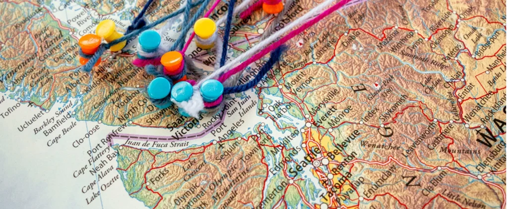 Colourful pins with strings attached to a map of British Columbia.