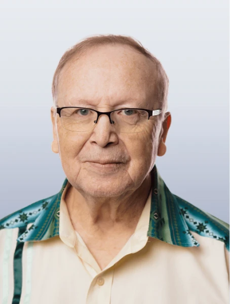 Raynie Gervais is smiling in a beige shirt with teal accents against a white background.