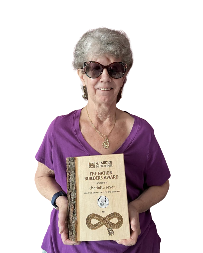 A woman in a purple shirt holding an engraved wooden award plaque.